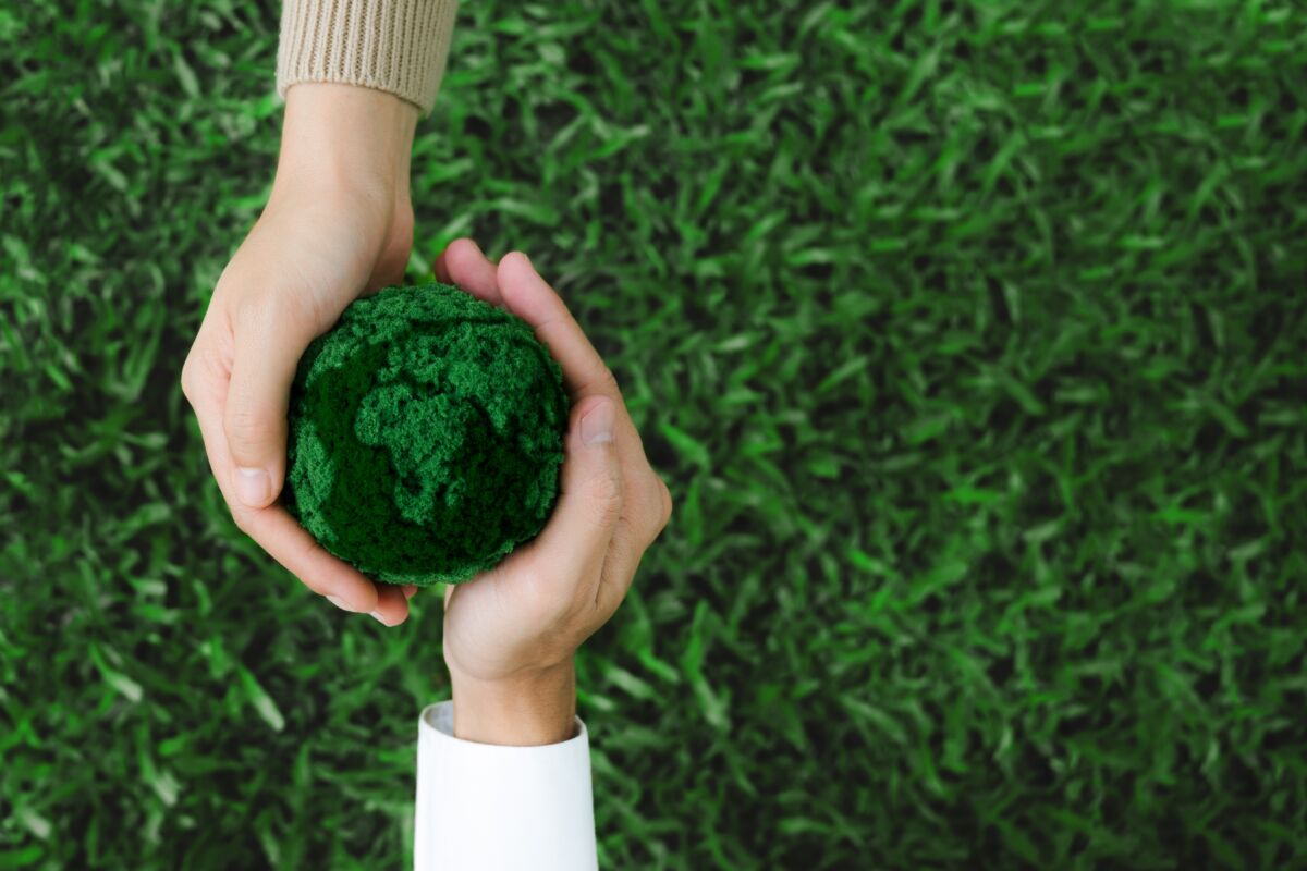 Two,Hands,Holding,Green,Earth,Together,On,Nature,Background,For