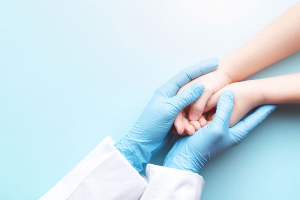 Doctor's,Hands,In,Gloves,Holding,Child's,Hands.,Medical,Care,Concept.